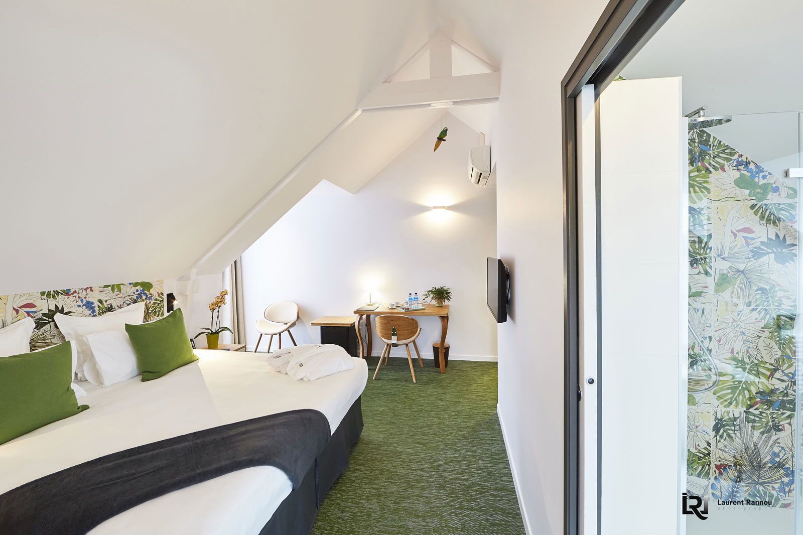 Ein Hotelzimmer mit Bett, Schreibtisch, Stuhl und Fernseher.