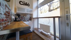 Une cuisine moderne avec un mur en briques, une table en bois et une fenêtre donnant sur des arbres.