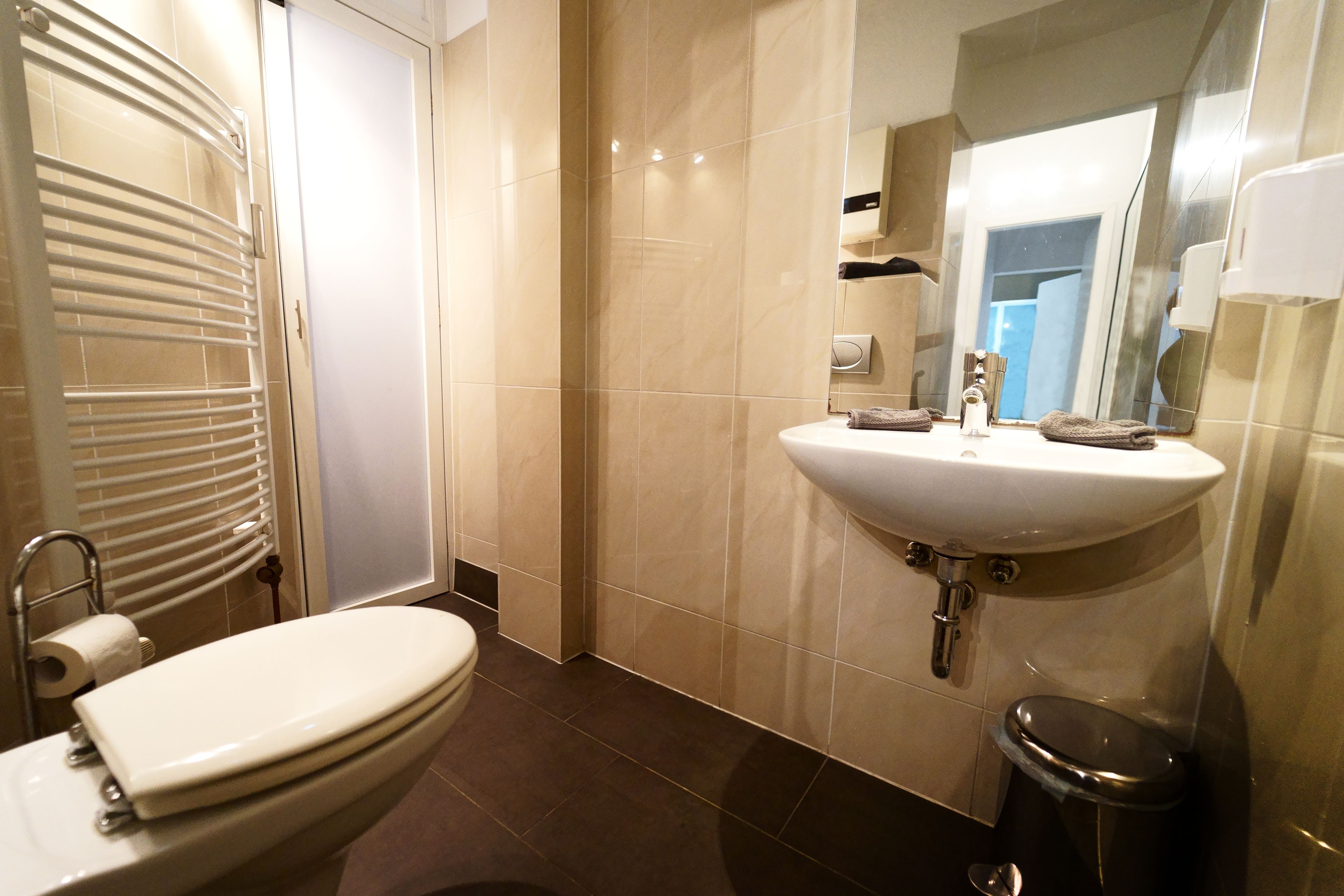 Une salle de bain moderne avec des toilettes, un lavabo et un miroir.