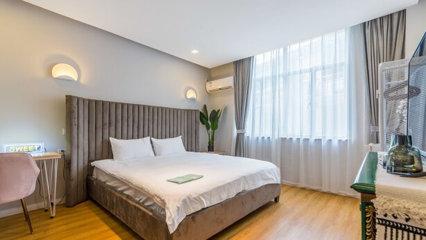A modern hotel room with a large bed, a bedside table, a chair, and a window with curtains. - Shanghai Moxi Inn Huaihai Rd No.6 Branch (Shanghai)