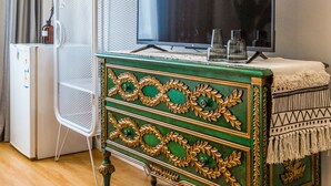 A room with a green and gold dresser, a television on top, and a white metal chair. - Shanghai Moxi Inn Huaihai Rd No.6 Branch (Shanghai)