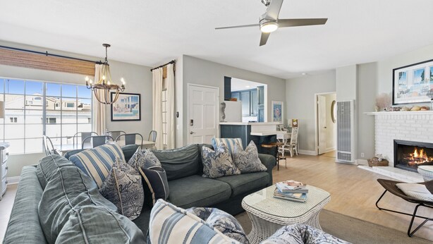 A spacious living room with a large gray sectional sofa, a round coffee table, and a fireplace.