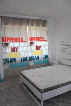 A bedroom with a bed, curtains with motivational words, a bedside table, and a wall clock. - PioppiHouse: Villa for groups or families with self-catering accommodations (Pioppi)