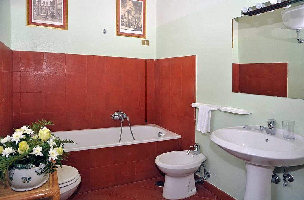 Une salle de bain équipée d’une baignoire, de toilettes, d’un bidet et d’un lavabo.