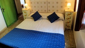 A bedroom with a bed, two nightstands, and a green door.