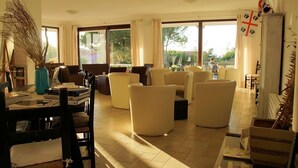 A spacious living area with large windows, comfortable seating, and a view of the outdoors.