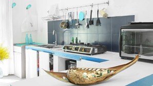 A modern kitchen with a gas stove, hanging pots and pans, and a large wooden bowl on the counter. - La Due Thulusdhoo (Thulusdhoo Island)