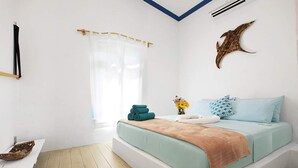 A bedroom with a bed, a window with curtains, a wall-mounted air conditioner, and a decorative wall piece. - La Due Thulusdhoo (Thulusdhoo Island)