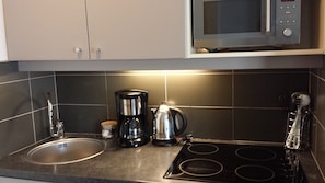 A kitchen with a stainless steel sink, a coffee maker, a kettle, and a microwave. - SUPERB 2 ROOMS - PARIS LA DEFENSE- RESIDENCE 4* (Courbevoie)