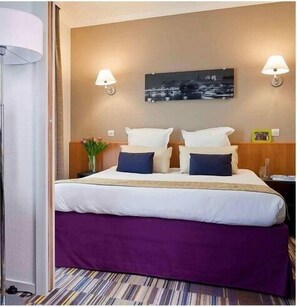 A hotel room with a bed, two wall-mounted lamps, a nightstand, and a framed picture on the wall. - SUPERB 2 ROOMS - PARIS LA DEFENSE- RESIDENCE 4* (Courbevoie)