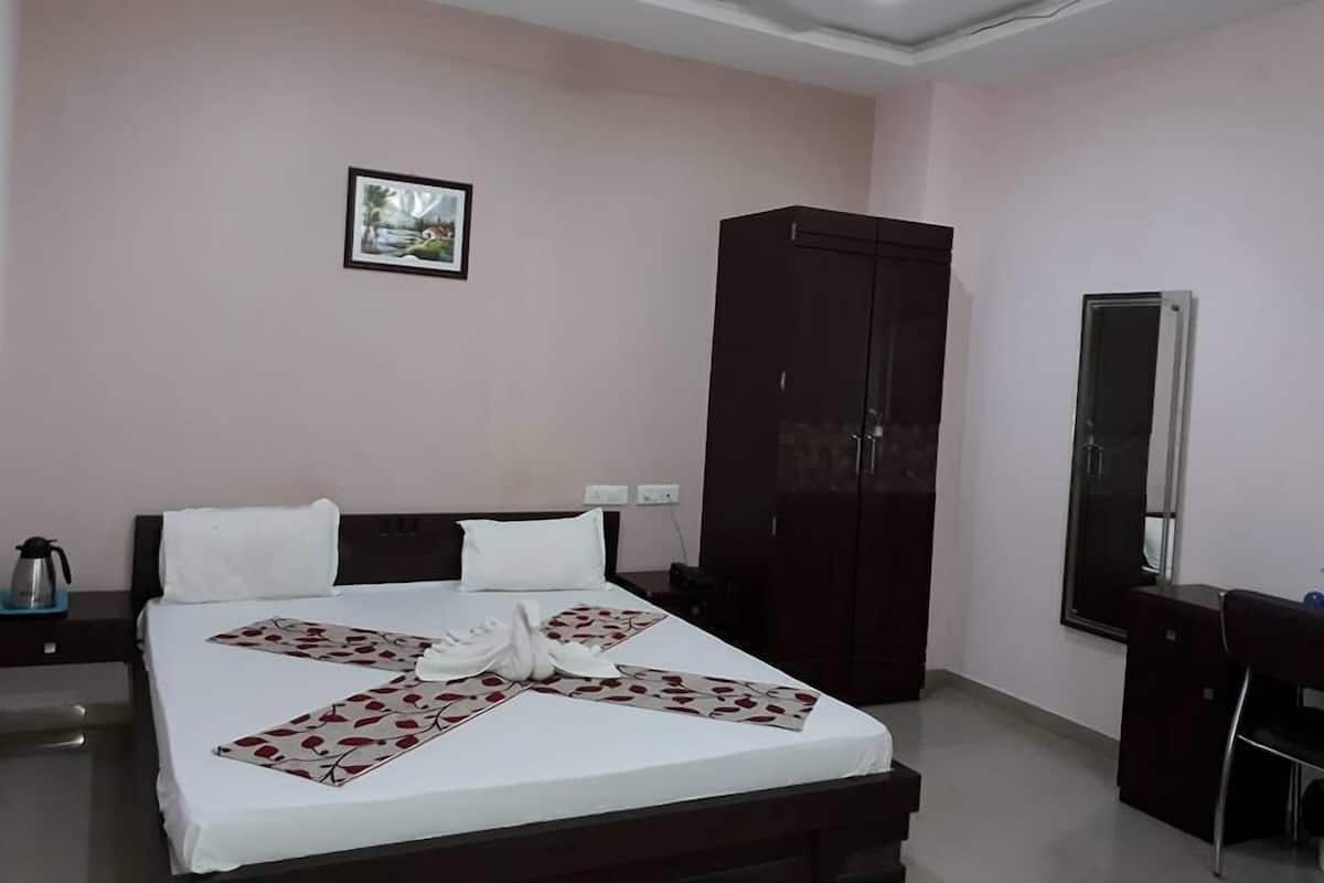 Ein Hotelzimmer mit Bett, Schrank, Schreibtisch und Stuhl.