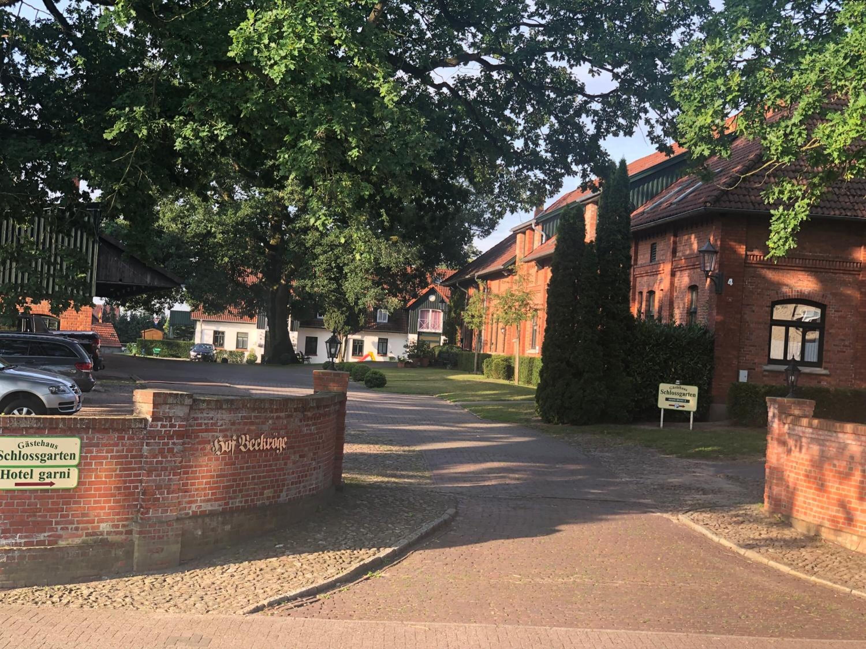 Een gebouw van baksteen met een bord waarop 'Gästehaus Schlossgarten Hotel garni' staat.
