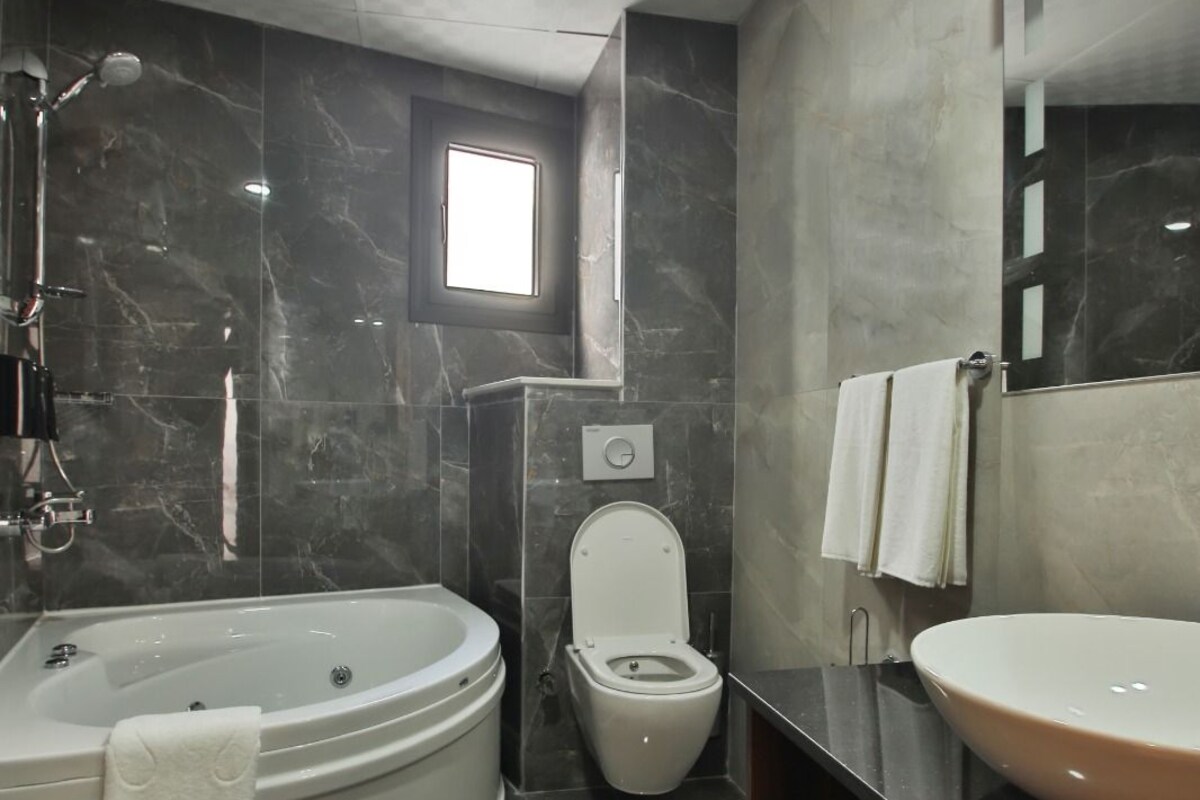 A modern bathroom with a bathtub, toilet, and sink.