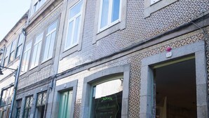 A building with a patterned facade, a green door, and a shop with a sign that reads "Vendo Colceirinho." - Merc Porto Central (Porto)