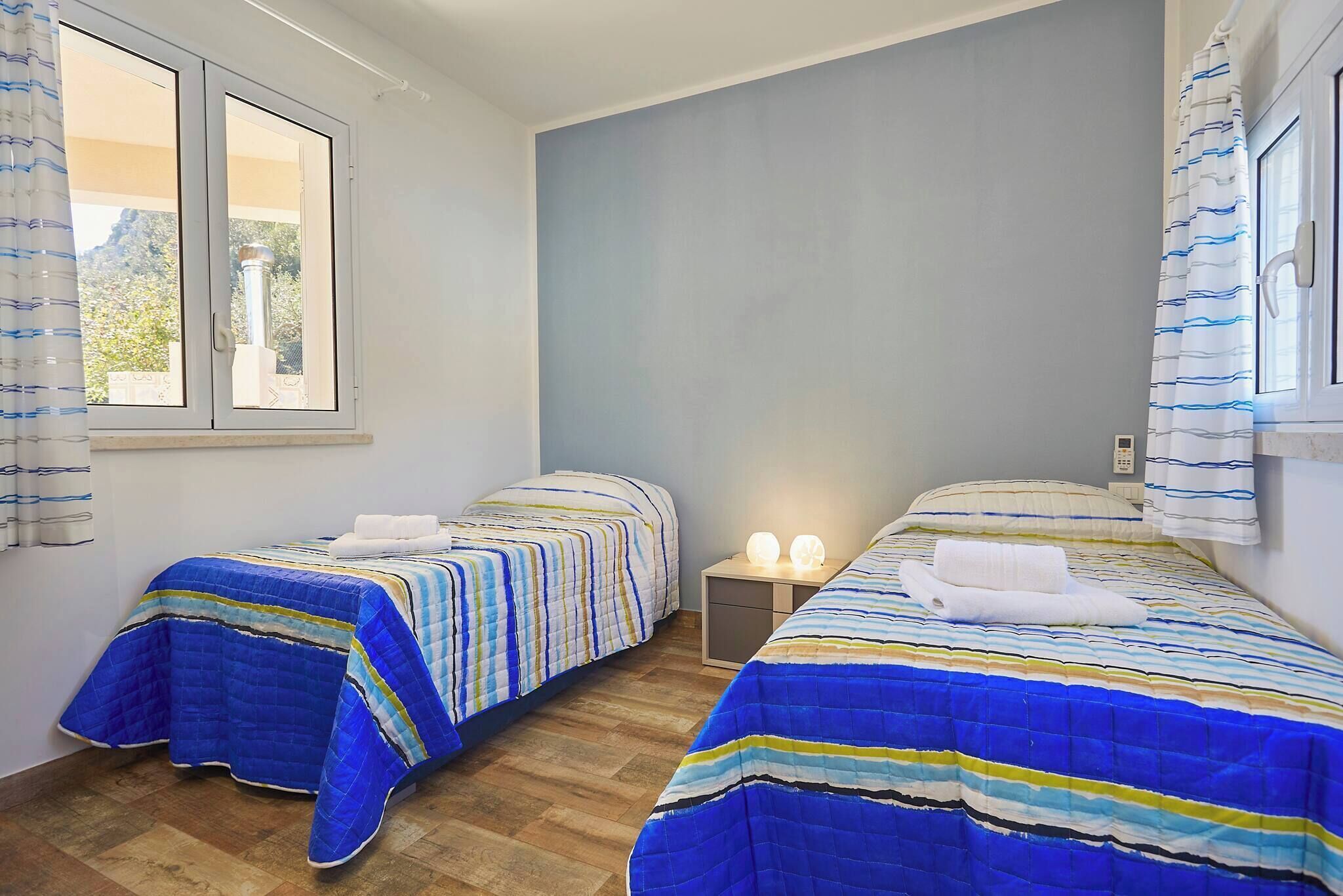 Une chambre avec deux lits, une fenêtre et une table de chevet avec deux lampes.