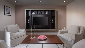 Una sala de estar moderna con dos sofás, una mesa de centro y un televisor de pantalla plana montado en la pared.
