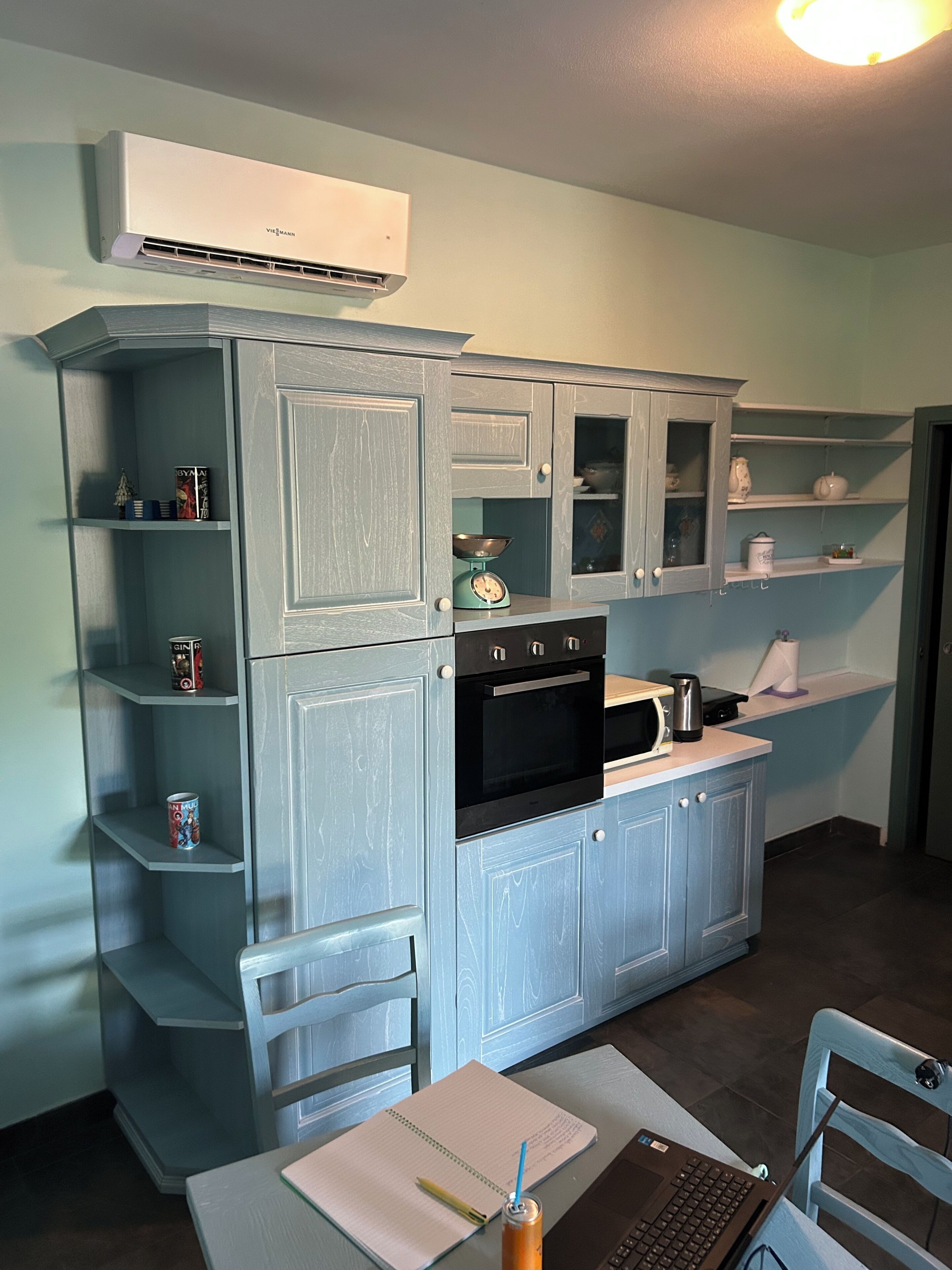 A kitchen with a built-in oven, microwave, and a small coffee maker on the counter.