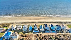 Une zone résidentielle côtière comprenant des maisons, une plage et une route.