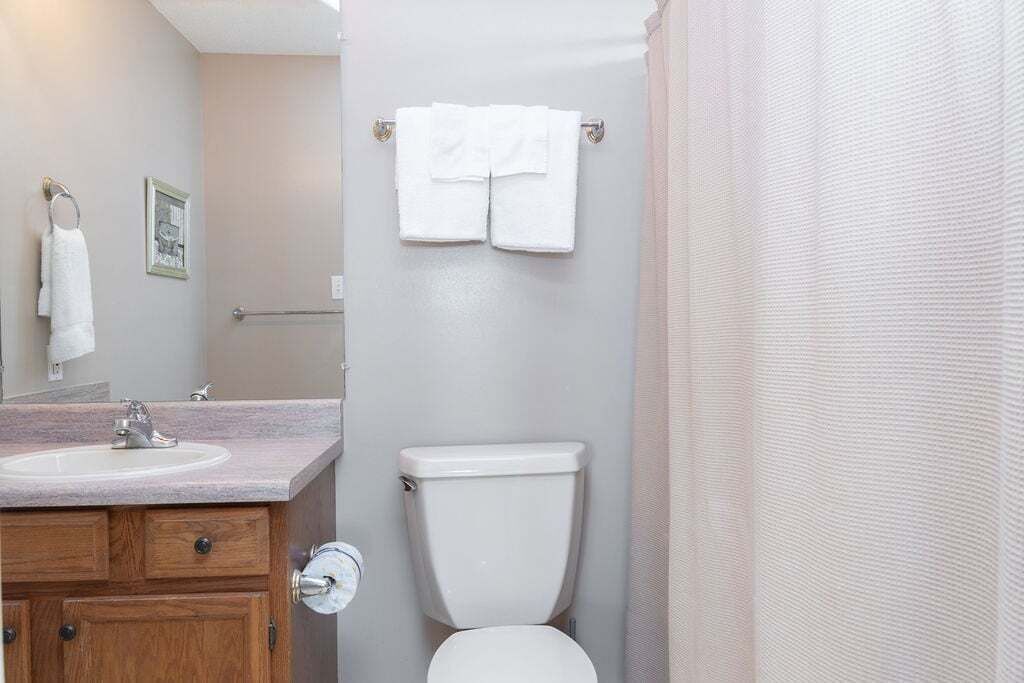 Une salle de bain équipée d’un lavabo, de toilettes et d’un porte-serviettes.