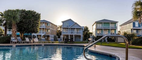Uma piscina com espreguiçadeiras e área ao redor da piscina.