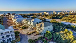 A coastal residential area with multiple two-story houses, a beach, and a clear sky. - Summer Palace B 2 Bedroom Duplex by RedAwning (Gulf Shores)