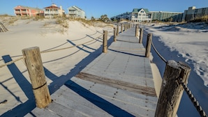 A wooden boardwalk leading to beach houses with multiple stories and balconies. - Summer Palace B 2 Bedroom Duplex by RedAwning (Gulf Shores)