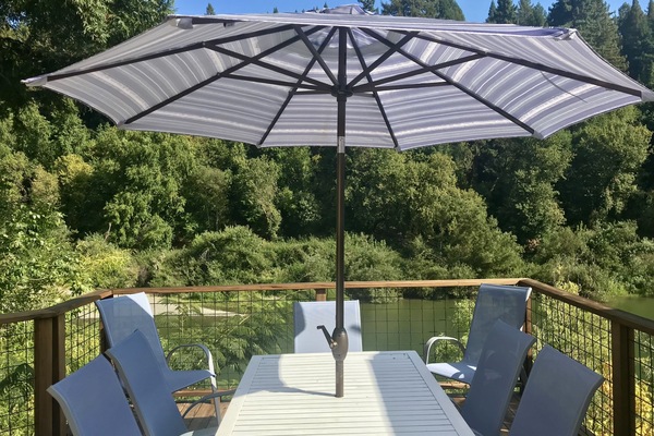 Deck overlooking the river with propane BBQ and seating for 8