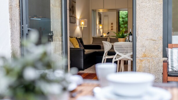 Um interior moderno com área de jantar, um sofá e uma mesa com cadeiras.