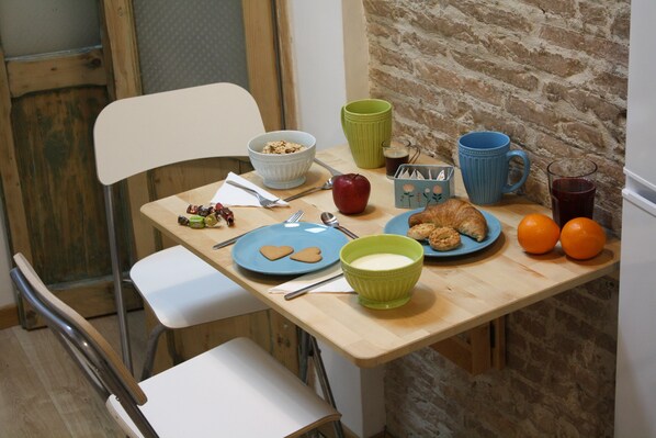 A breakfast table with plates, bowls, and cups.