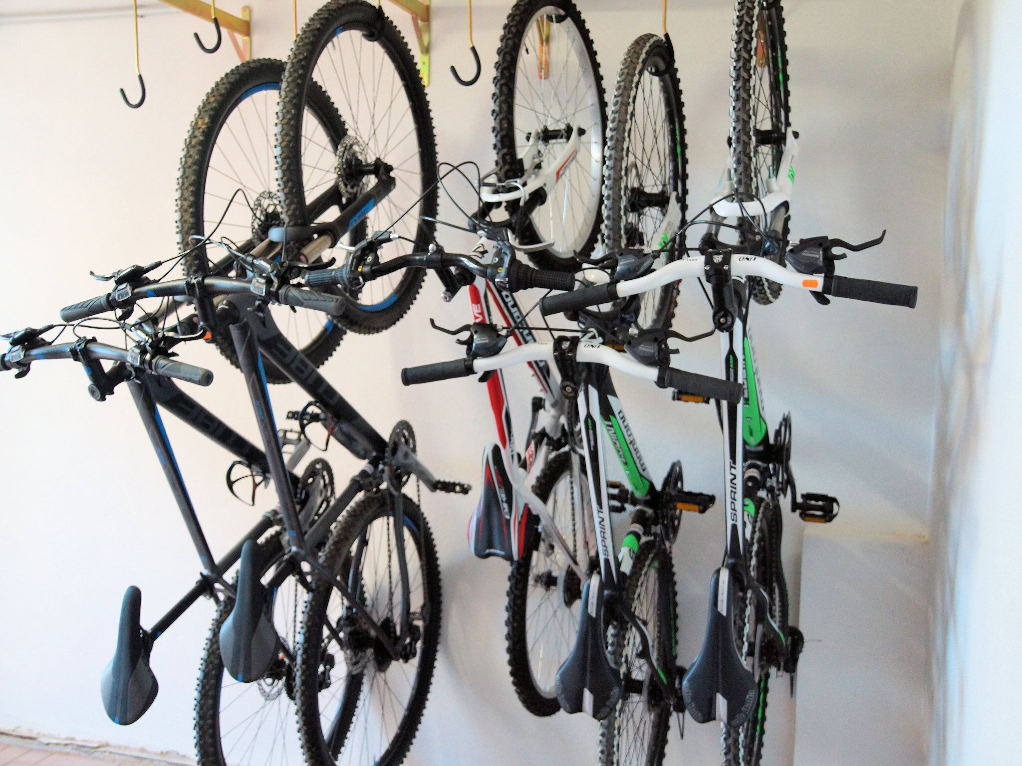 A wall-mounted bike rack with multiple bicycles.