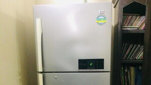 A silver refrigerator with a digital display, a white handle, and a sticker. - Redwan's home (Dhaka)