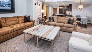 A spacious living room with two sofas, a coffee table, and a dining area with chairs and a table. - Ge Inn Plaza #109 4 Bedroom Condo by RedAwning (Vail)