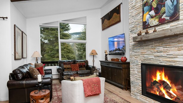 A living room with a fireplace, a sofa, a coffee table, and a fireplace mantle with decorative items.
