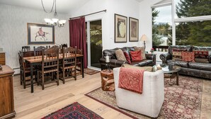 A spacious living room with a dining area, a sofa set, and a chandelier.