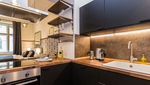 A modern kitchen with a built-in oven, a coffee maker, and a sink. - PRG Trendy Central APT by Michal&Friends (Prague)