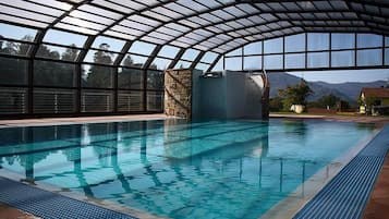 Una piscina al aire libre de temporada, sombrillas