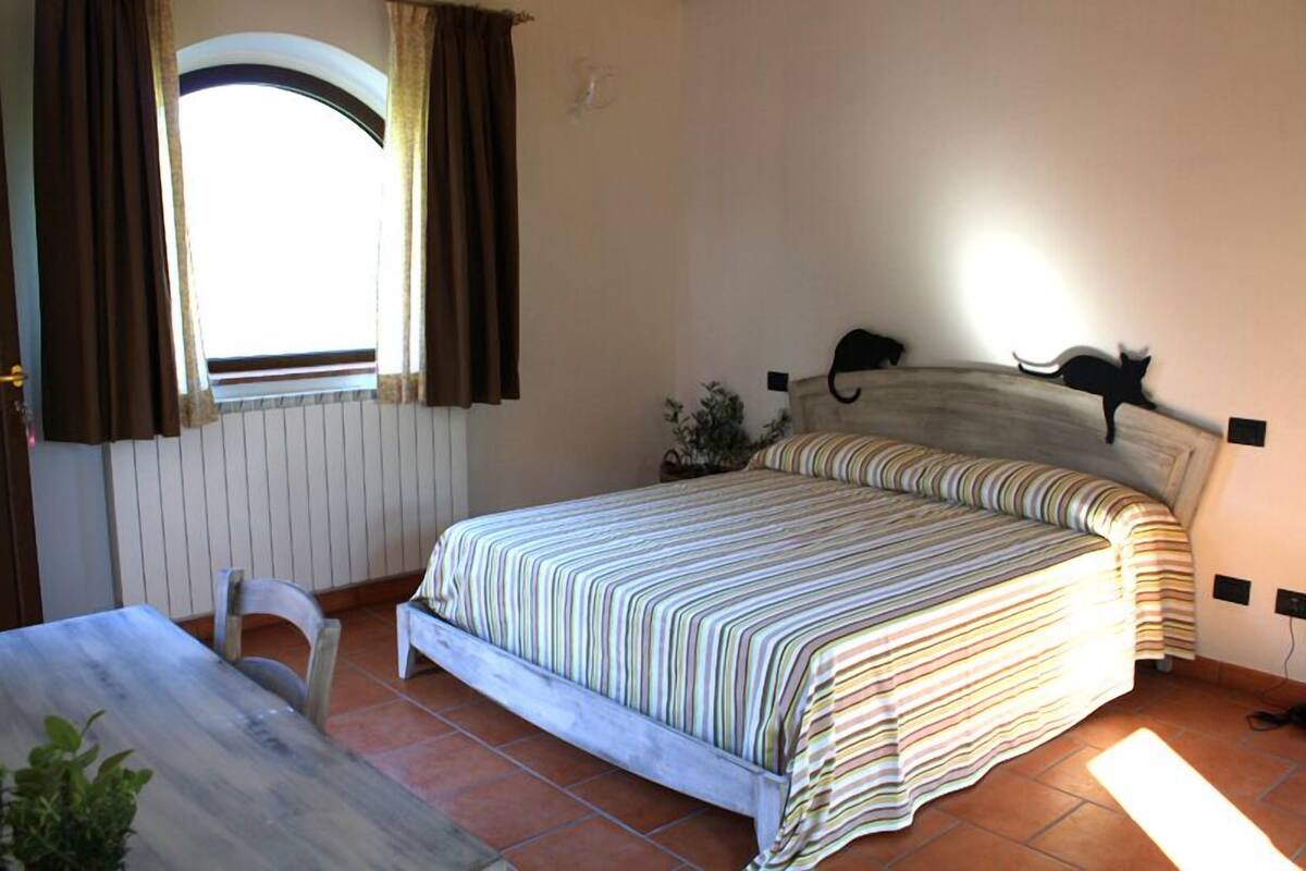 Un dormitorio con cama, escritorio y silla.