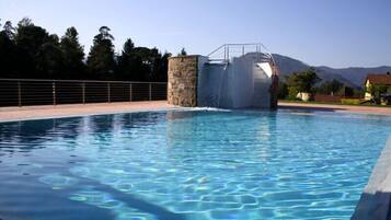 Enjoy a refreshing swim surrounded by lush trees and a mountain range.
