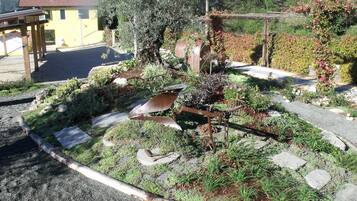 Een tuin met verschillende planten en een rustieke metalen constructie.