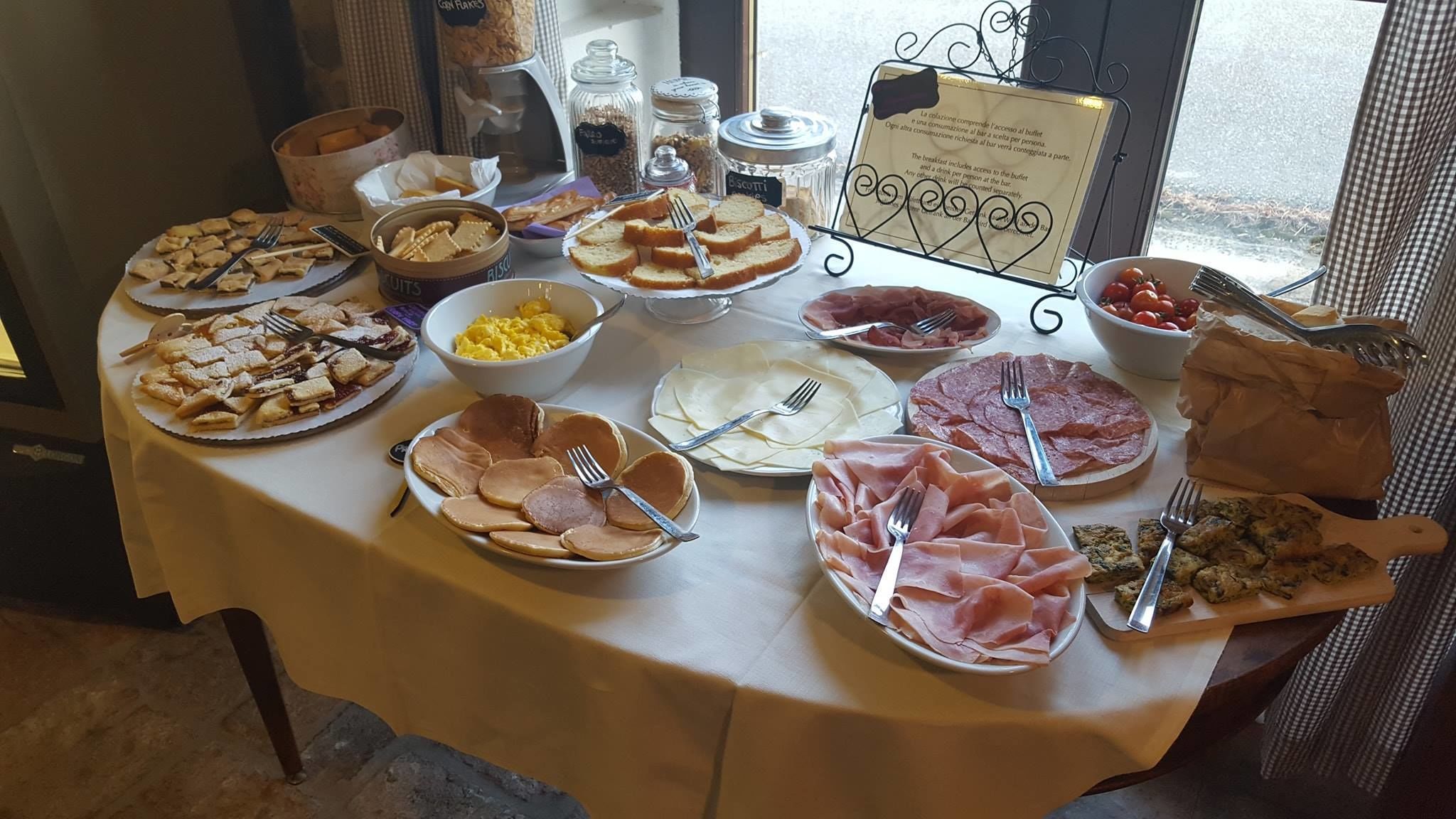 A buffet table with various food items including pastries, meats, and condiments.