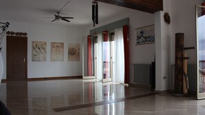 A spacious room with a polished floor, a ceiling fan, and a wooden door.
