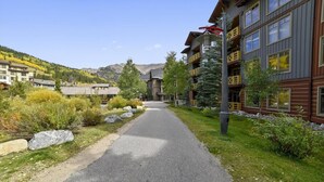 A pathway leading to a building with a mountain backdrop. - Tucker Mountain Lodge 102 2 Bedroom Condo by RedAwning (Copper Mountain)