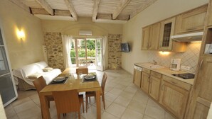 A compact kitchen with wooden cabinets, a dining table with chairs, and a built-in oven. - 2-room apartment with terrace 800 meters from the beaches (CANNES)