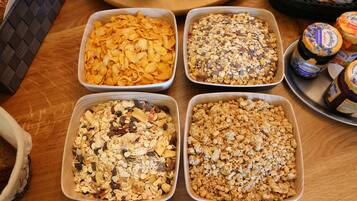 Cuatro fuentes rectangulares de granola sobre una mesa de madera.