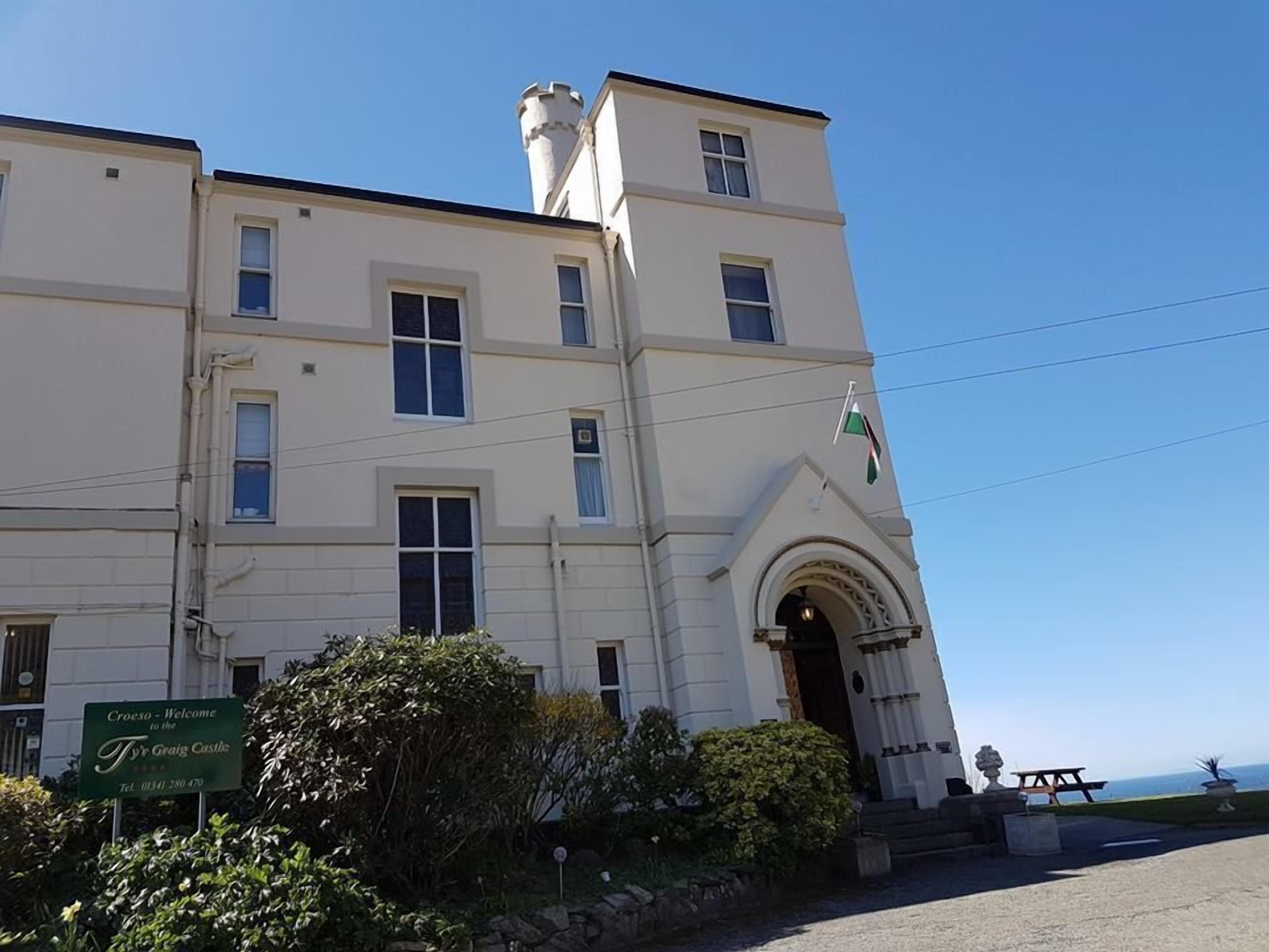 A large, two-story building with a prominent entrance and a flag.