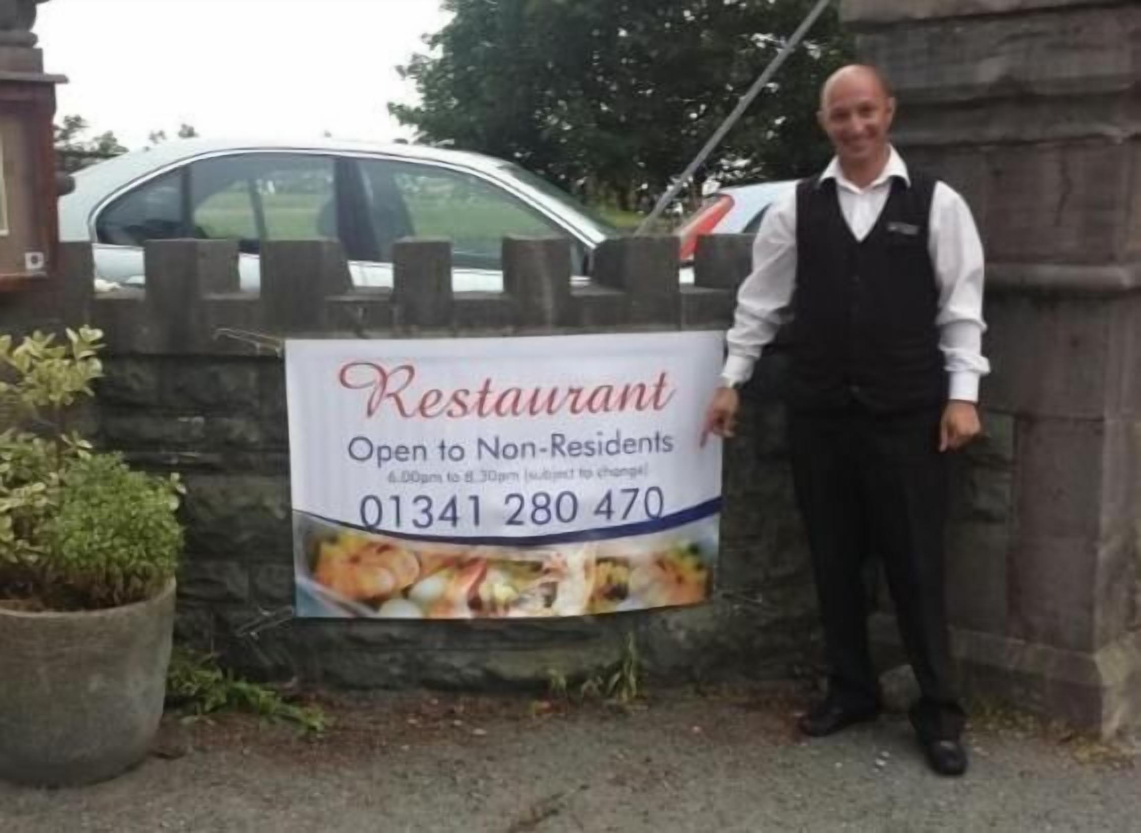A sign for a restaurant open to non-residents, with a phone number 01341 280 470.