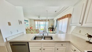 A kitchen with white cabinets, a double sink, and a dishwasher. - South Shores I 3 2 Bedroom Condo by RedAwning (Surfside Beach)