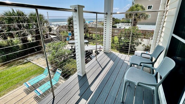 A balcony with a view of the ocean, a pool, and a building in the background. - South Shores I 3 2 Bedroom Condo by RedAwning (Surfside Beach)
