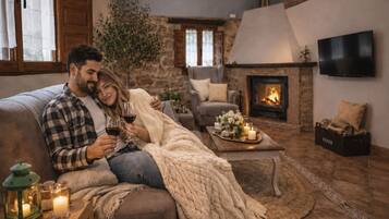 A cozy living room with a fireplace, a sofa, and a coffee table with candles.