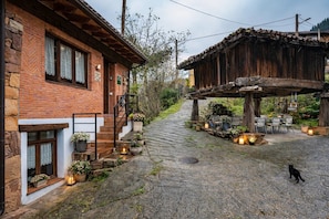 A rustic building with a stone facade, a wooden porch, and outdoor seating.